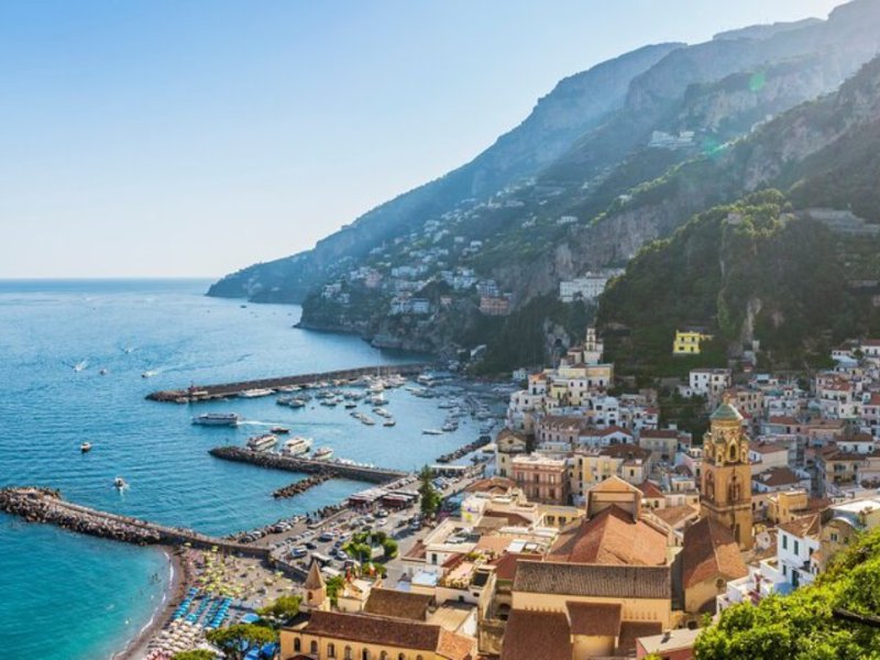 Scenic view of a coastal town with colorful buildings and blue sea under a clear sky.